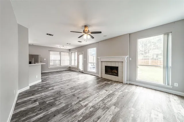 wooden floor fireplace and windows in an empty room