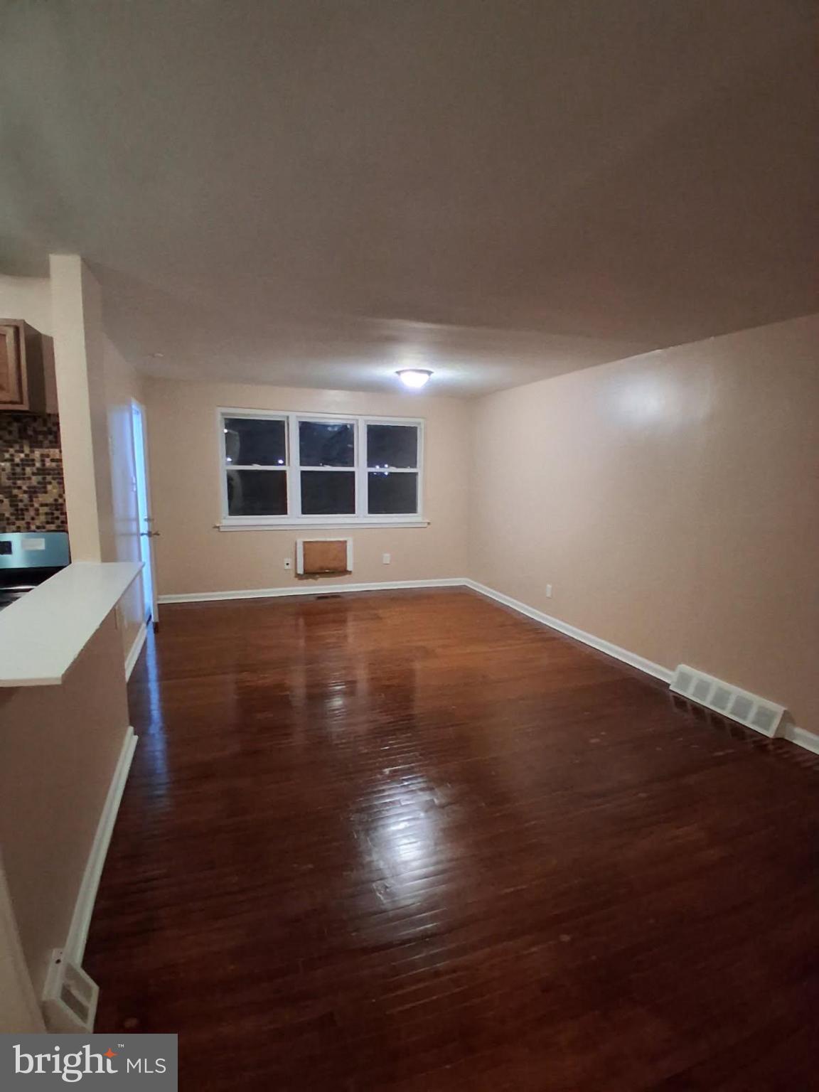 Spacious room with polished hardwood floors.
