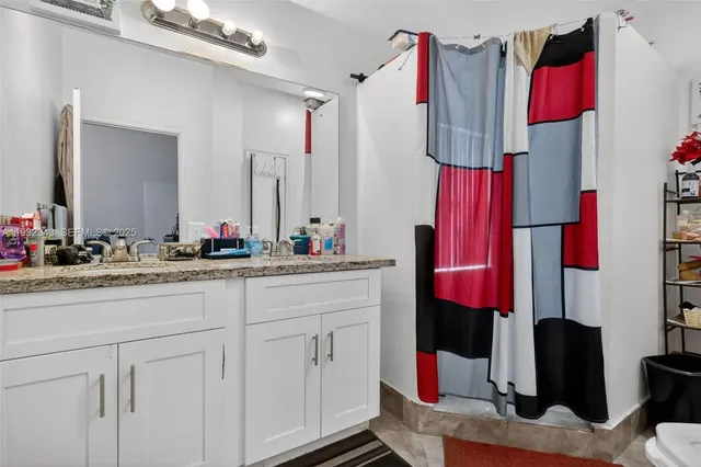 a bathroom with a toilet and a shower curtain