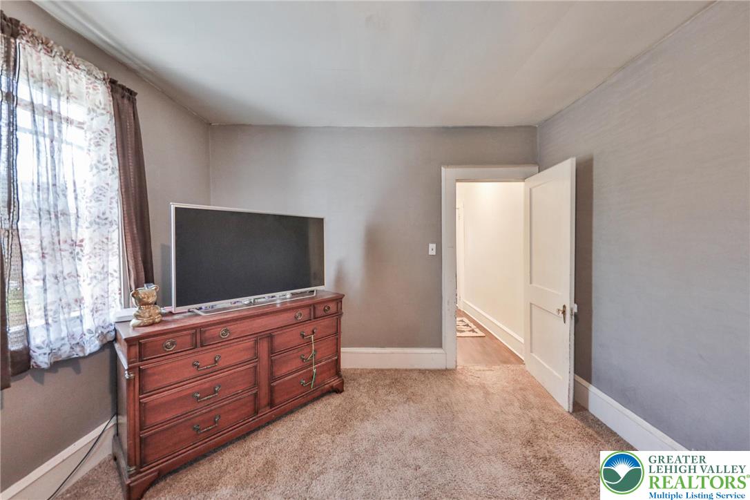 417 3rd Street Lehighton, PA 18235 - Photo 14 of 39 This cozy bedroom features a sun-filled window and plush carpeting, creating a comfortable retreat.