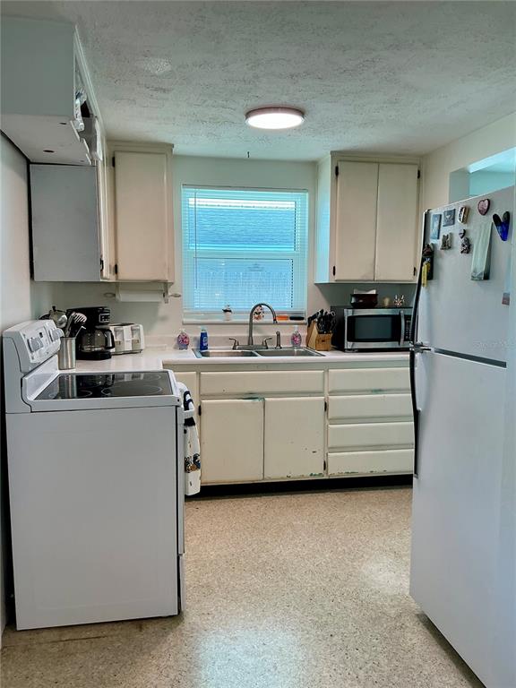 3020 Hawthorne Street Sarasota, FL 34239 - Photo 14 of 22 a kitchen with white cabinets and white appliances