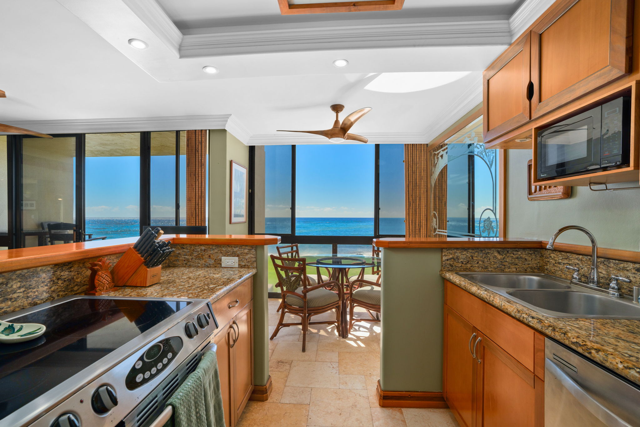 5050 Lawai Road, Unit 113 Koloa, HI 96756 - Photo 3 of 18 a kitchen with a stove a sink and a microwave