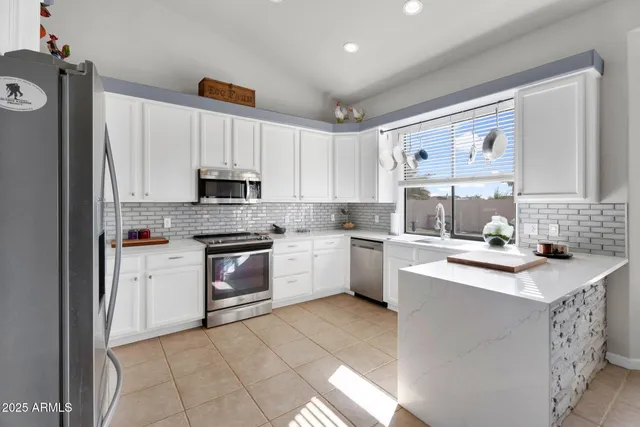 a kitchen with granite countertop a refrigerator stove top oven and sink