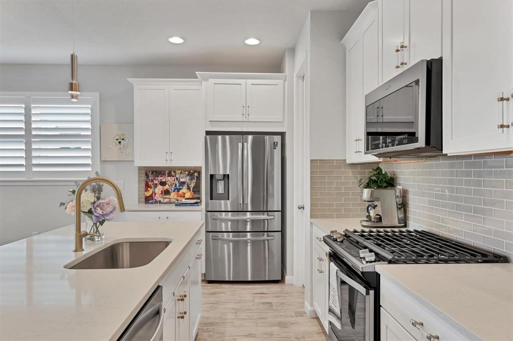 8733 Rain Song Road Sarasota, FL 34238 - Photo 11 of 39 a kitchen with refrigerator a stove a sink and a microwave