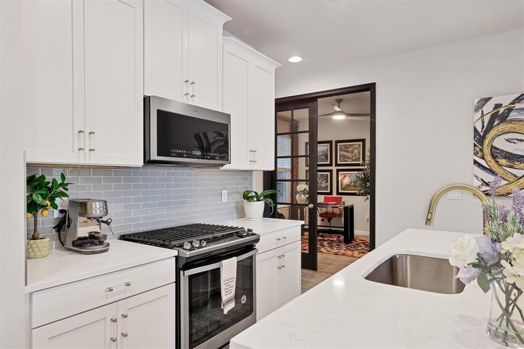 8733 Rain Song Road Sarasota, FL 34238 - Photo 12 of 39 a kitchen with stainless steel appliances granite countertop a sink stove and white cabinets