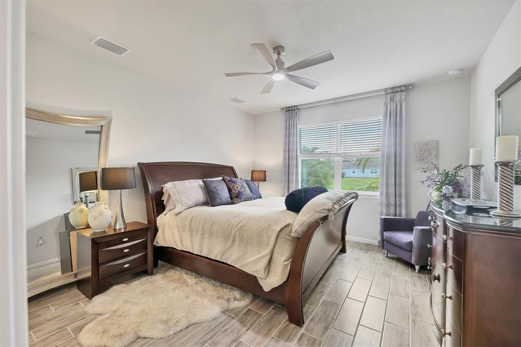 8733 Rain Song Road Sarasota, FL 34238 - Photo 13 of 39 a bedroom with a bed and wooden floor