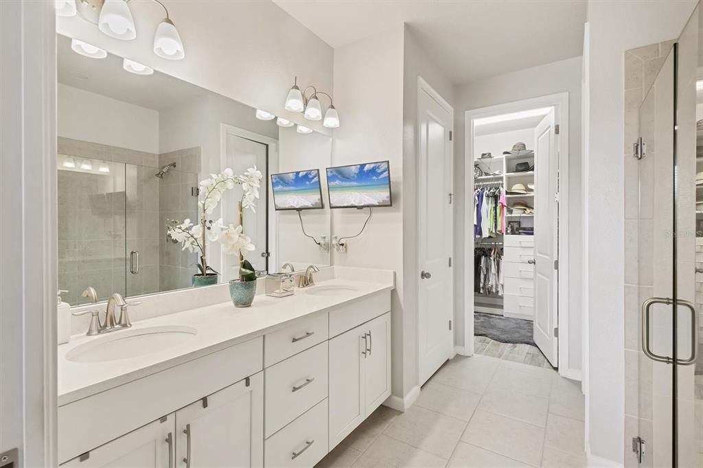 8733 Rain Song Road Sarasota, FL 34238 - Photo 14 of 39 a spacious bathroom with a double vanity sink a large mirror a shower and a bathtub