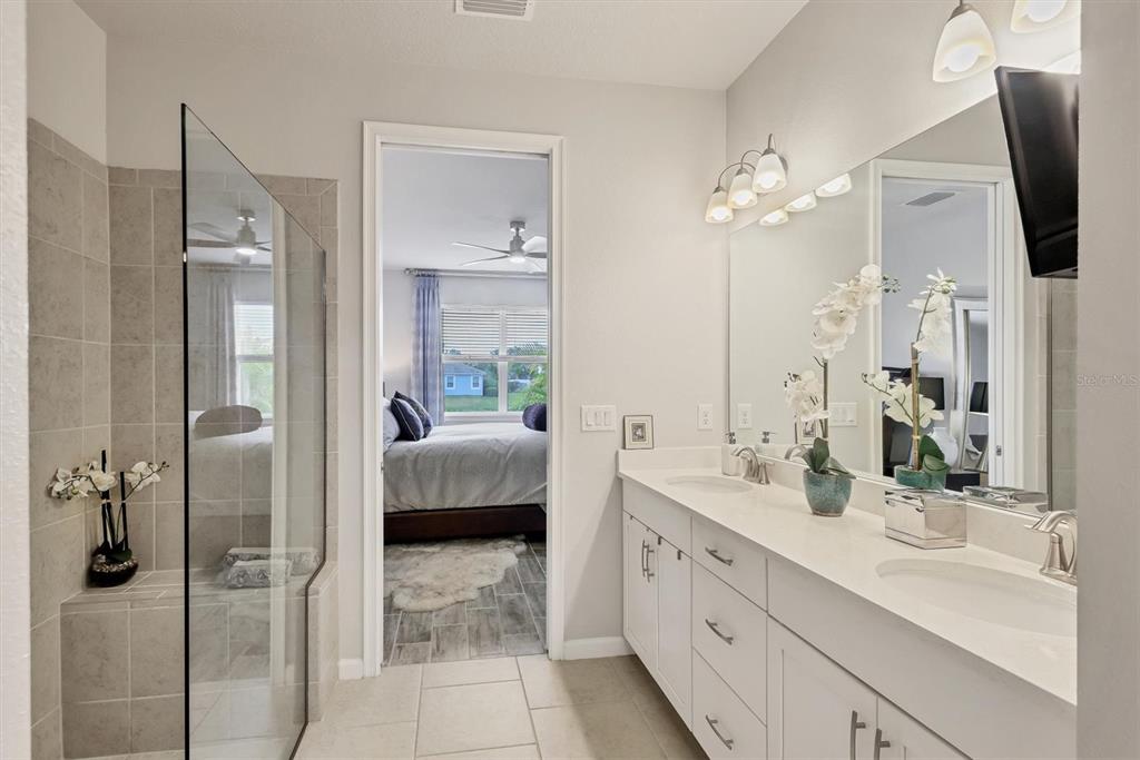 8733 Rain Song Road Sarasota, FL 34238 - Photo 15 of 39 a en suite bathroom with a double vanity sink a mirror and shower