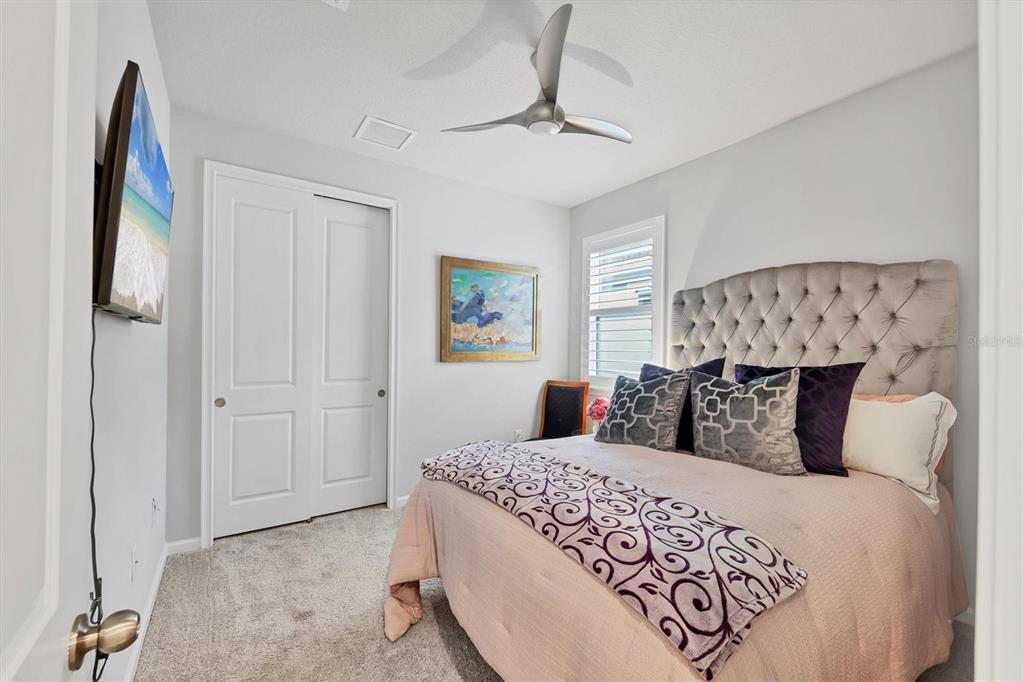 8733 Rain Song Road Sarasota, FL 34238 - Photo 16 of 39 a bedroom with a large bed and a chandelier