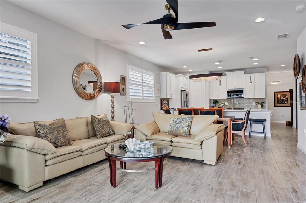 8733 Rain Song Road Sarasota, FL 34238 - Photo 6 of 39 a living room with furniture kitchen view and a wooden floor