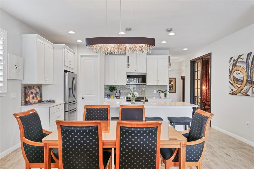 8733 Rain Song Road Sarasota, FL 34238 - Photo 7 of 39 a kitchen with stainless steel appliances kitchen island granite countertop a dining table and chairs