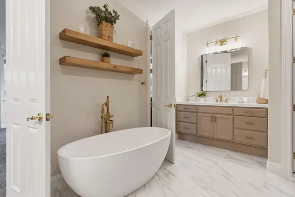 a spacious bathroom with a double vanity sink mirror and bathtub