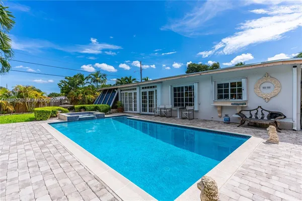 a view of a house with swimming pool and sitting area