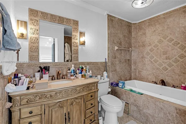 a bathroom with a granite countertop toilet a sink and a mirror