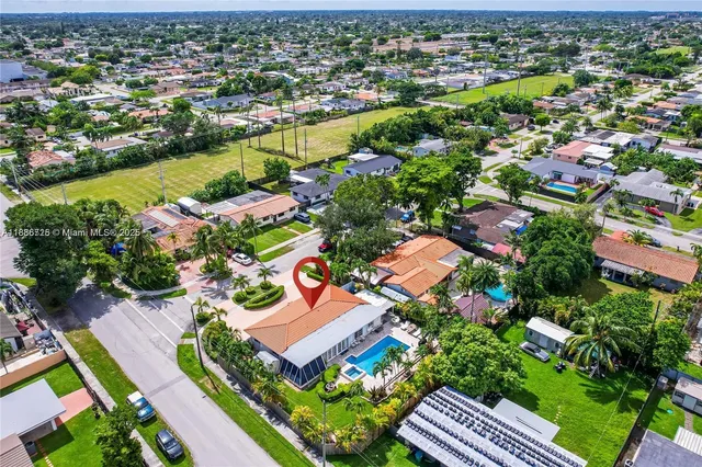 an aerial view of residential houses with outdoor space and swimming pool