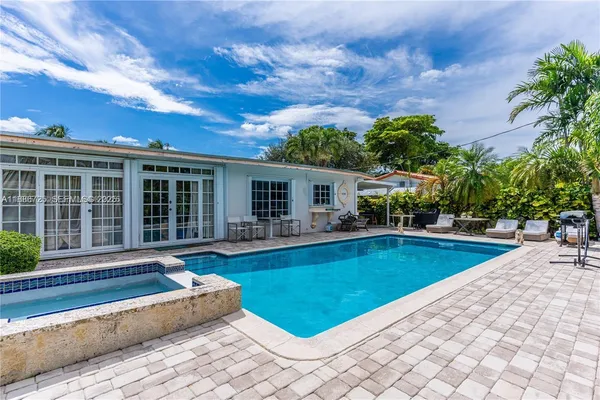 a view of a house with swimming pool and sitting area