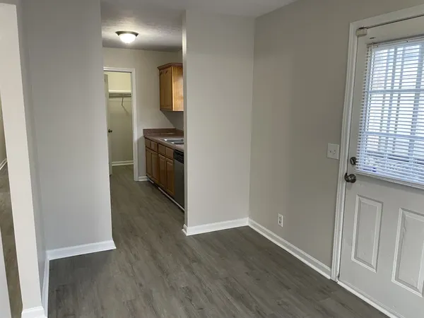 an empty room with wooden floor and a window