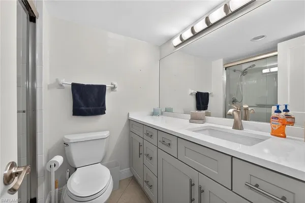 a spacious bathroom with a toilet a sink and mirror