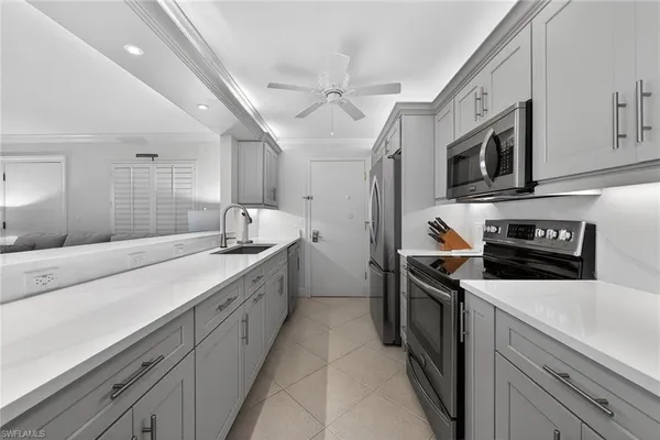 a kitchen with stainless steel appliances sink stove microwave and cabinets