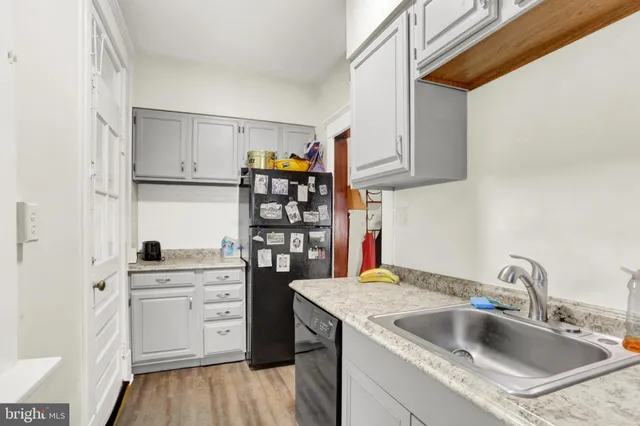 a kitchen with granite countertop white cabinets and a sink