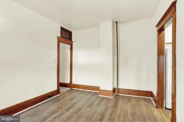 a view of a white house with a large tree