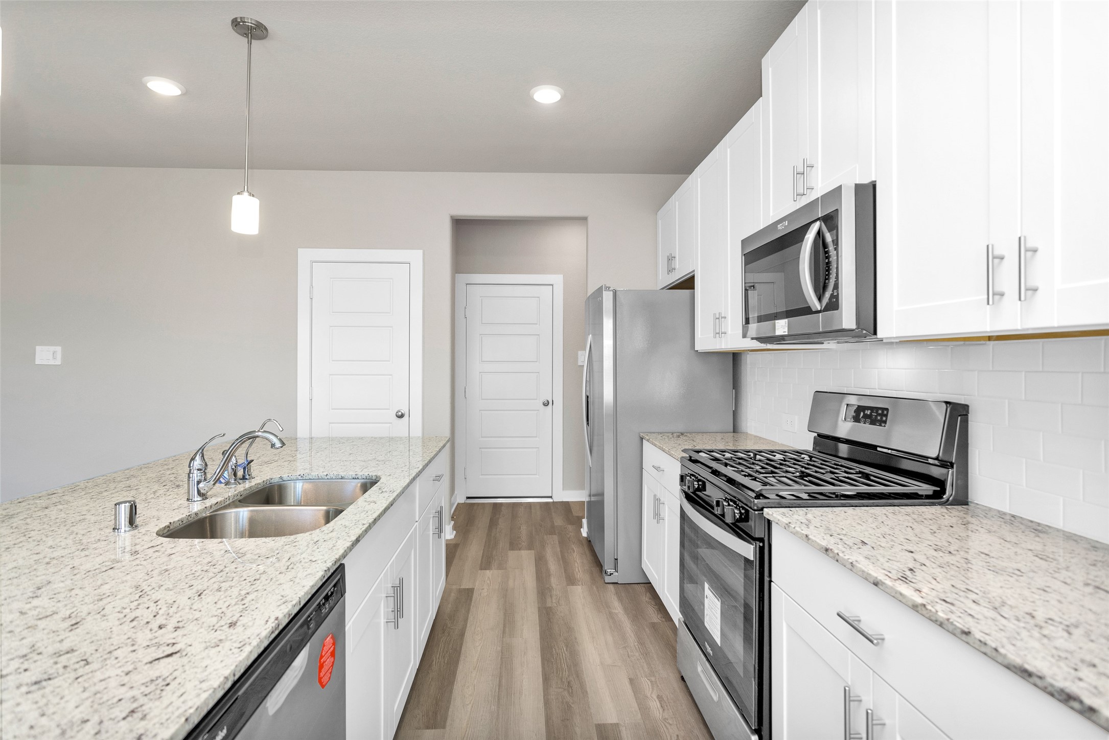 1406 Waggoner Rnch Trail Conroe, TX 77301 - Photo 16 of 43 a kitchen with stainless steel appliances granite countertop a sink stove and refrigerator