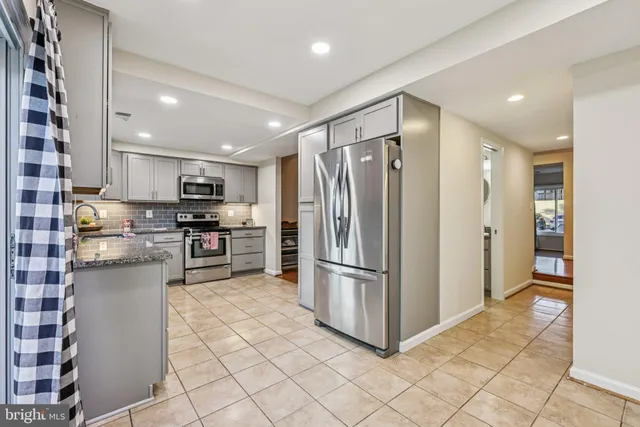 a kitchen with stainless steel appliances granite countertop a sink and a window