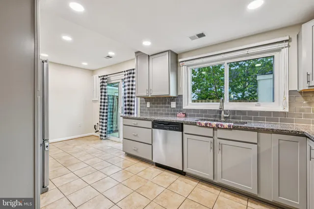 a kitchen with stainless steel appliances granite countertop a refrigerator and a sink