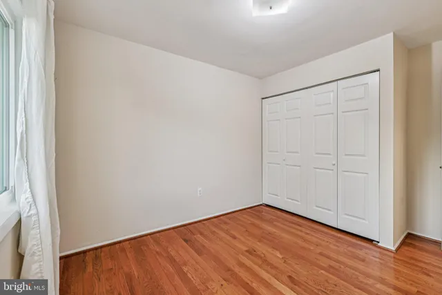a view of an empty room with wooden floor