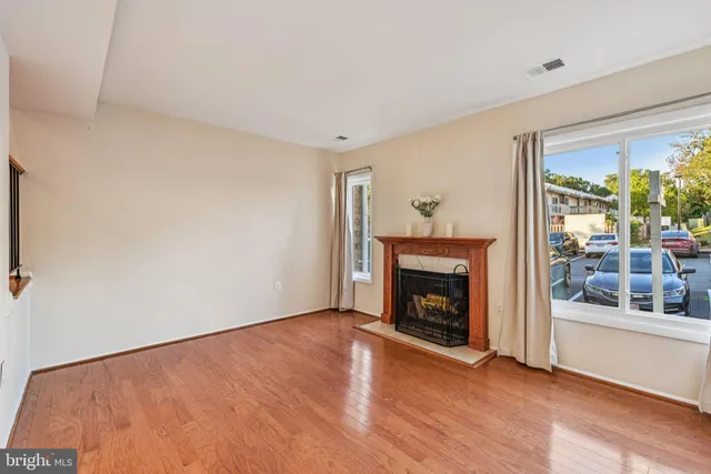 a view of an empty room with window and fire place
