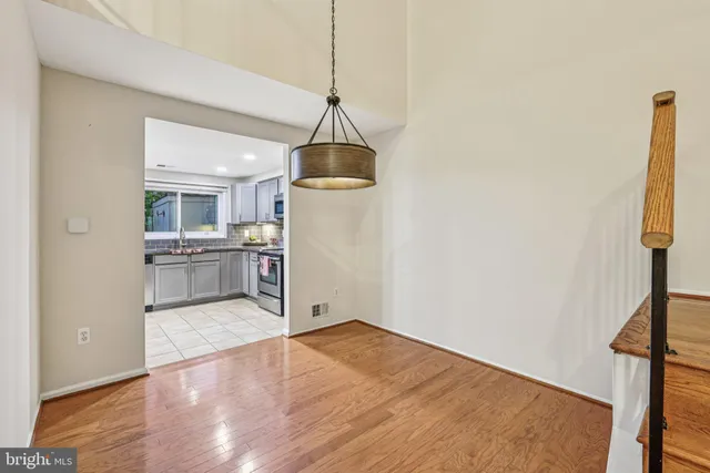 wooden floor in an empty room with kitchen view