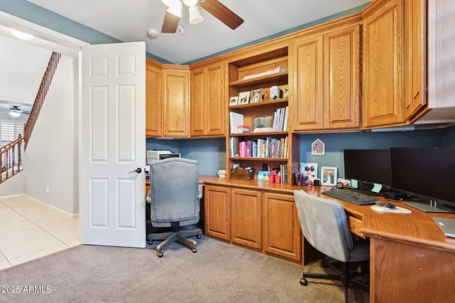a view of a workspace with furniture and a window