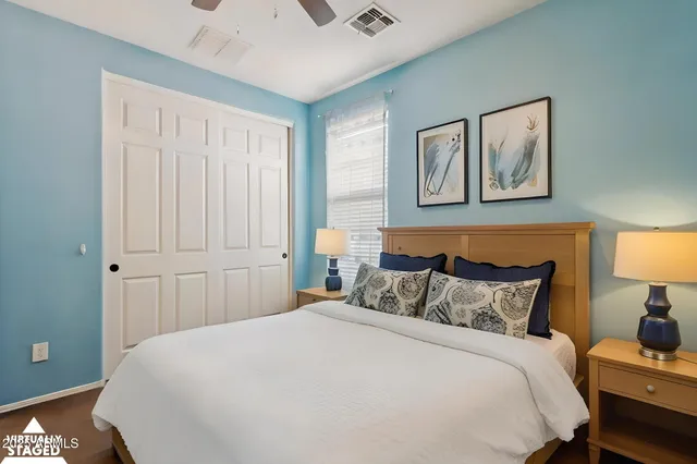 a bedroom with a bed and a lamp on dresser