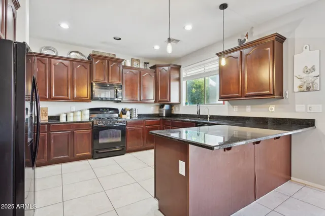 a kitchen with kitchen island granite countertop a sink window and stainless steel appliances
