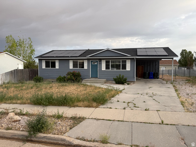 Ranch-style exterior with gray siding, white window shutters, and a teal entry door
