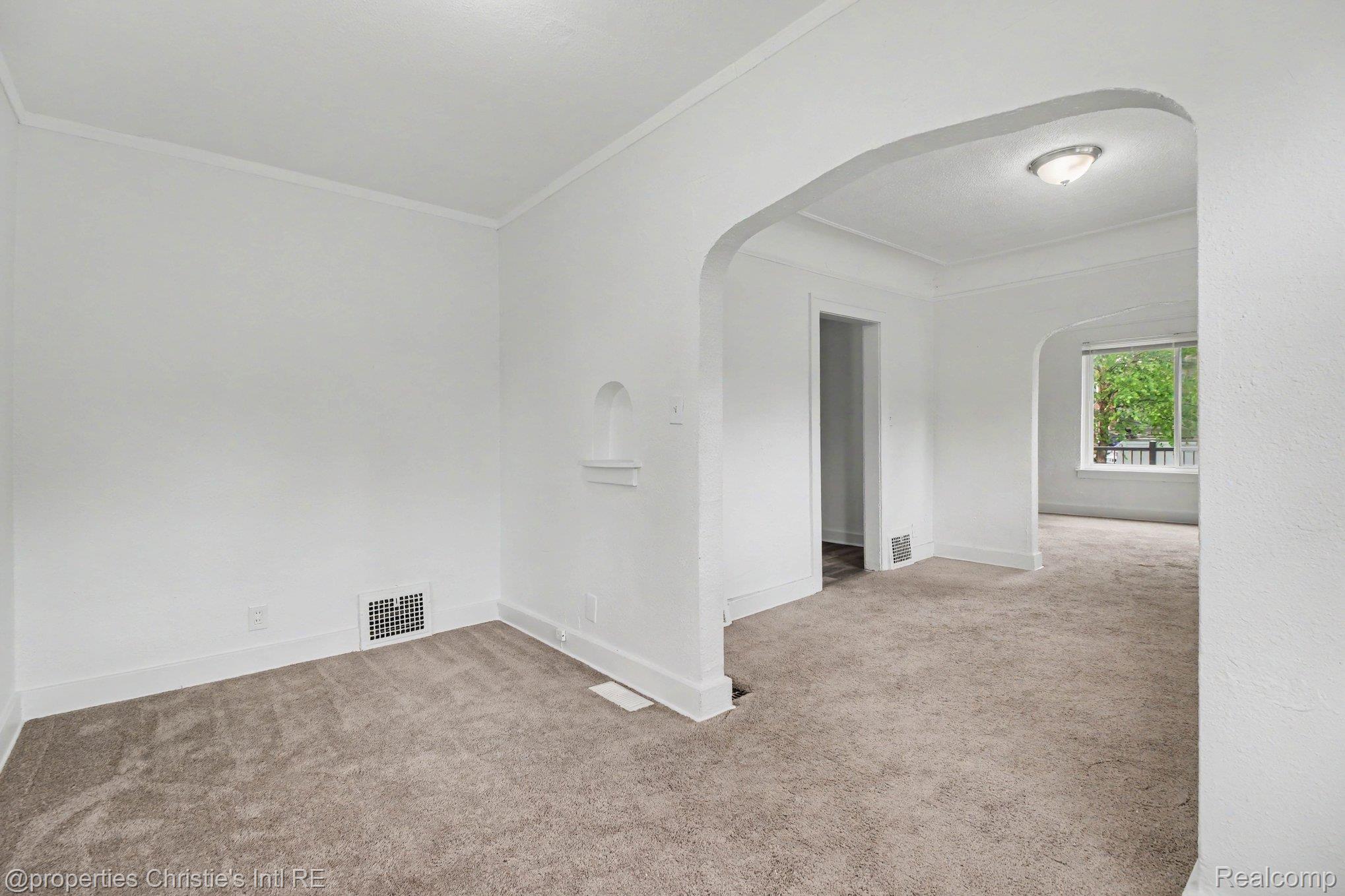 5911 Yorkshire Road Detroit, MI 48224 - Photo 5 of 14 Archway entry framing a light-filled interior with neutral carpeting, white baseboards, and a built-in wall niche