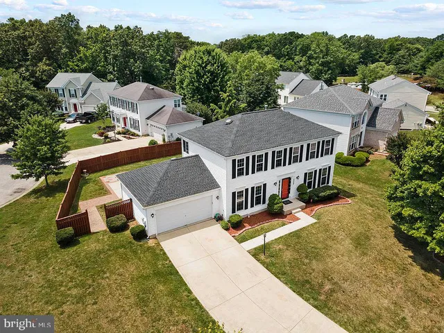 an aerial view of a house with swimming pool and large trees