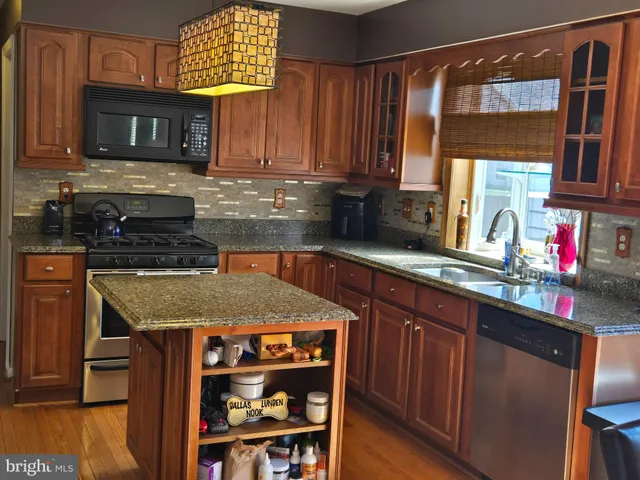 a kitchen with stainless steel appliances granite countertop a refrigerator a stove top oven a sink and dishwasher