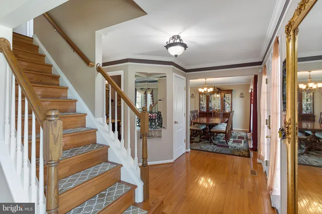a view of a dining room with furniture a chandelier and wooden floor
