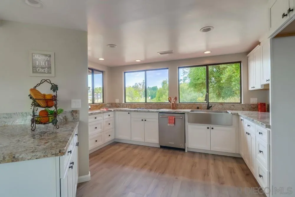 1660 Grove Road El Cajon, CA 92020 - Photo 8 of 44 a kitchen that has a lot of cabinets in it and wooden floors