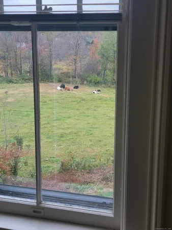 a view of a room with a large window and wooden floor