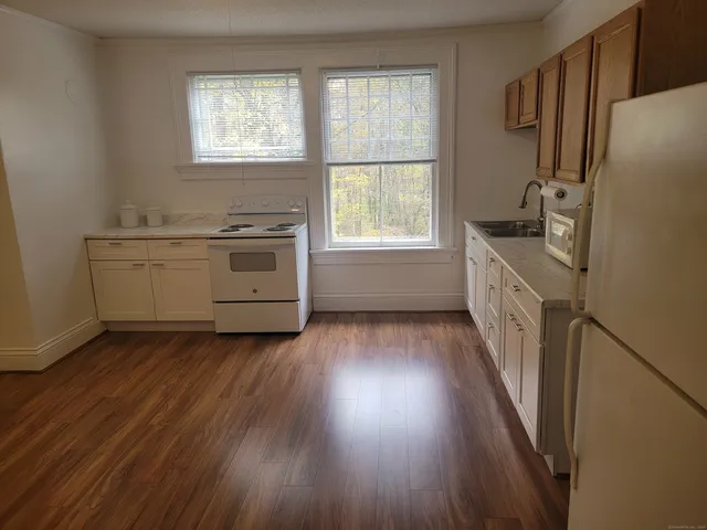 a kitchen with wooden floors and white appliances