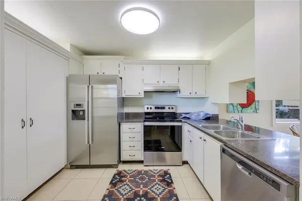 a kitchen with granite countertop a sink stove and cabinets