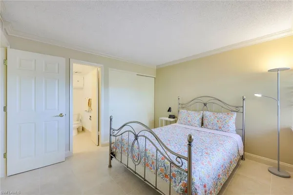 a bed sitting in a bedroom next to a lamp