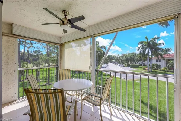 a view of a porch with furniture and a yard