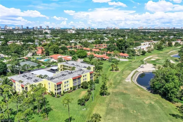 an aerial view of a city with lots of residential buildings ocean and mountain view in back