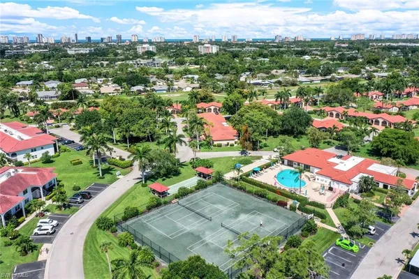 an aerial view of residential houses with outdoor space and trees