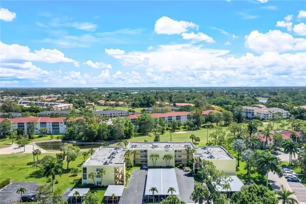 an aerial view of residential houses with outdoor space and trees