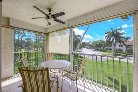a view of a porch with furniture and a yard