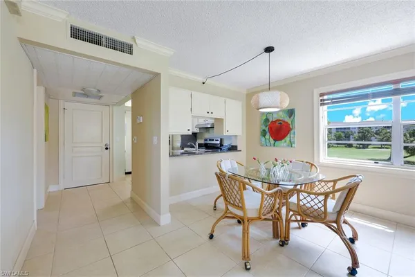 a view of a dining room and livingroom with furniture wooden floor a chandelier